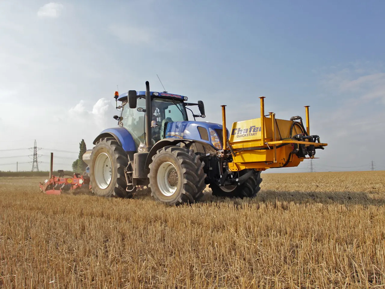 In this picture we can see a person is sitting in a tractor. Behind the tracks there are electric...