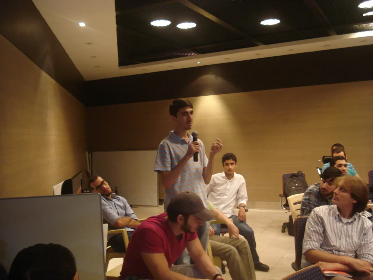 In this picture we see many young persons. Here we see a person who is standing, he holds a...