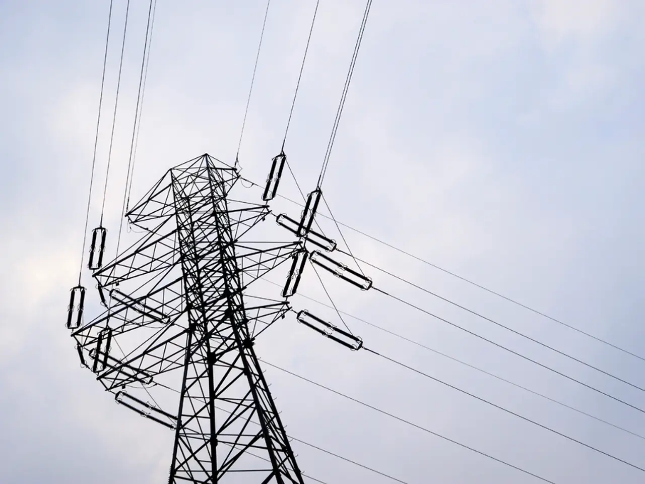 This image is taken in outdoors. In the middle of the image there is a signal tower with wires. In...