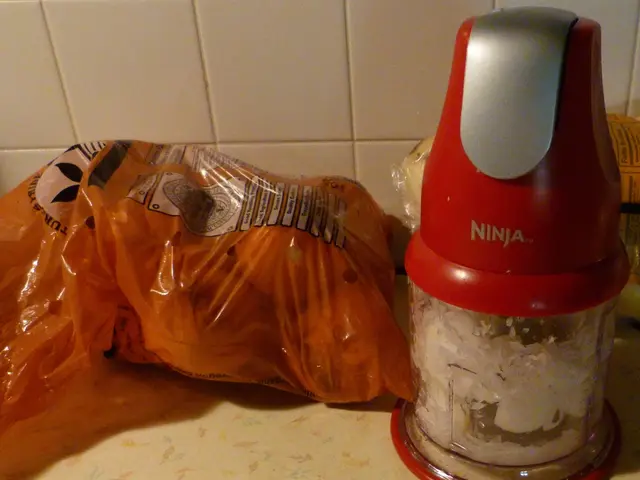 In this image there is a grinder, there is a packet of some items in it , and there is an object,...