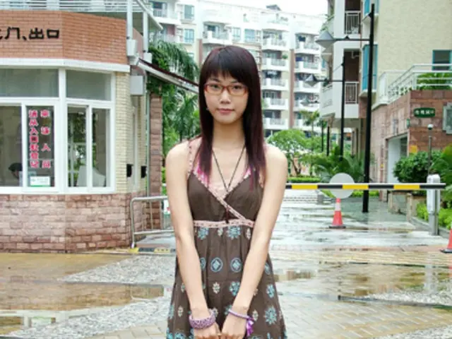 This is the woman standing and holding the hand bag in her hands. These are the buildings. I can...