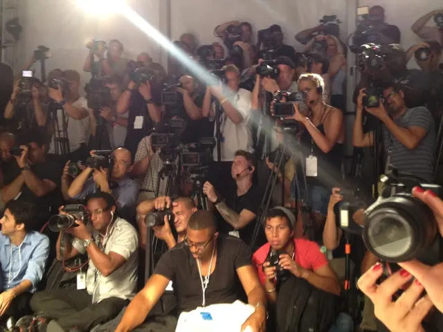 In the image there are a lot of people capturing photos and videos with the cameras, every person...