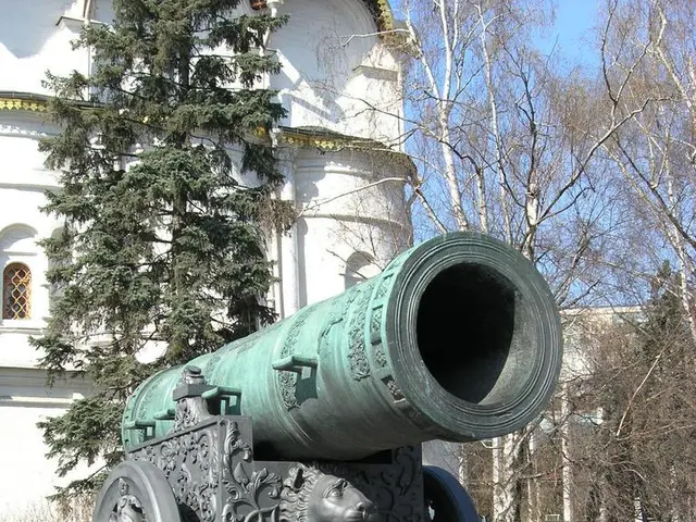 In this image we can see tsar cannon, behind this there is a building and trees.